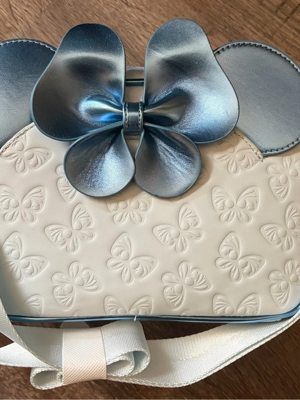Loungefly Cream Crossbody Bag with Metallic Blue Bow Accent